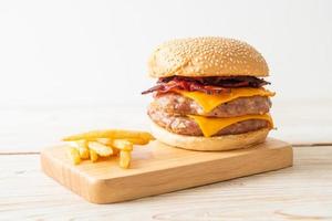 hamburger di maiale o hamburger di maiale con formaggio, pancetta e patatine fritte foto