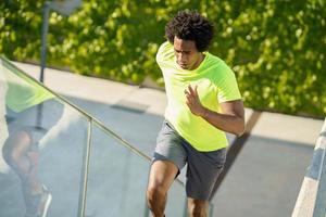 uomo di colore che corre di sopra all'aperto. giovane maschio che si esercita. foto