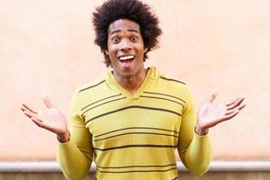 uomo di colore con i capelli afro che mette un'espressione divertente foto