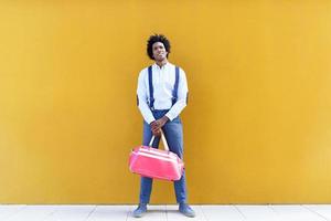 uomo di colore con acconciatura afro che porta una borsa sportiva foto