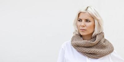 donna in caldo scaldacollo in maglia di lana beige foto