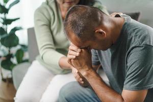 amico o famiglia seduto e tenersi per mano rallegrare l'uomo depresso mentale foto