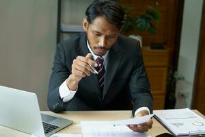 attività commerciale uomo Lavorando con il computer portatile. giovane attività commerciale uomo pensiero concentrato a opera. foto