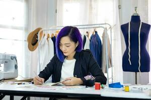 alla moda libero professionista sarta è progettazione su nuovo vestito di disegno illustratore mentre Lavorando nel sua artistico laboratorio studio per moda design e capi di abbigliamento attività commerciale industria foto