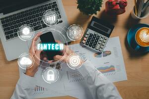 Fintech finanziario tecnologia criptovaluta investimento e digitale i soldi, attività commerciale persona utilizzando inteligente Telefono su ufficio scrivania con Fintech icona su vr schermo. foto