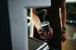 avvicinamento di fabbricazione latte schiuma, sferzata latte nel professionale vapore caffè macchina foto