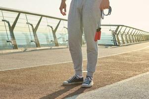 ritagliata Visualizza di un' sportivo Tenere un' salto corda mentre in piedi su un' routine durante un' mattina cardio allenarsi foto