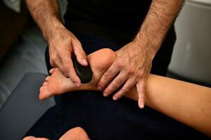 avvicinamento di massaggiatore l'esecuzione ayurvedico massaggio utilizzando vulcanico caldo pietra. terme trattamento concetti foto