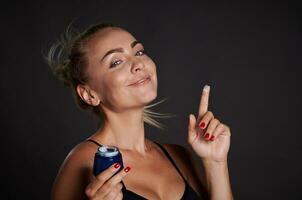 bellissimo mezzo anziano donna sorrisi mentre Tenere anti rughe facciale crema nel sua mani. gioventù concetto e prevenzione di primo segni di invecchiamento processi. pubblicità studio tiro al di sopra di nero sfondo foto