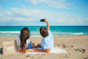 giovane coppia assunzione autoscatto di smartphone su il spiaggia foto