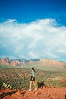 giovane escursionista donna su il bordo di un' scogliera a Cattedrale roccia nel sedona, Arizona. Visualizza a partire dal panoramico Cattedrale roccia nel sedona con blu cielo nel Arizona foto