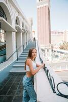 bellissimo giovane ragazza sfondo il famoso Hotel nel las Las Vegas, in piedi nel il occupato città. famoso turista attrazione nel Stati Uniti d'America su vacanza nel las Las Vegas. foto