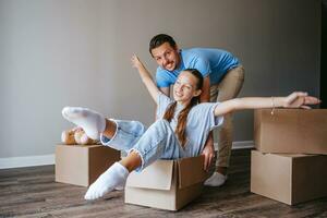 famiglia avere divertimento su in movimento giorno nel loro nuovo casa foto