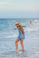 bellissimo adolescente ragazza su tropicale riva del mare a piedi a superficiale acqua e avendo divertimento foto