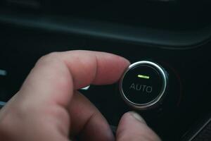 mano regolazione il aria condizionatore pulsante nel il auto foto