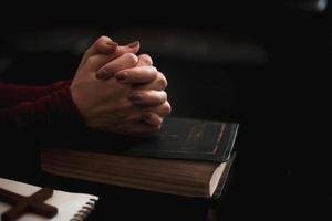 mano della donna che prega sulla Sacra Bibbia al mattino. foto