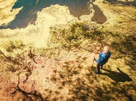 vista dall'alto in basso donna anziana in piedi con bastoncini nordici foto