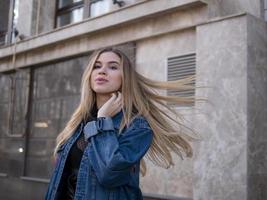 ragazza attraente con capelli splendidi in una giacca di jeans foto