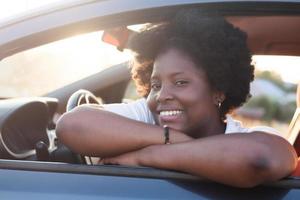 felice donna afroamericana in macchina, stile di vita foto