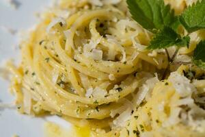 un' piatto di pasta con un' verde foglia su superiore foto