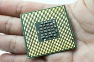 chip del processore vista posteriore della CPU realistica in mano su sfondo bianco foto