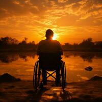 silhouette di un' sedia a rotelle utente contro tramonto, raffigurante forza e incrollabile spirito per sociale media inviare dimensione ai generato foto