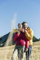 Austria, tirolo, contento coppia Abbracciare una persona su un' escursioni a piedi viaggio nel il montagne foto