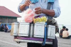 asiatico maschio strada venditore vendita rampollo nenek spuntini o cotone caramella foto