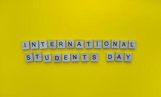 novembre 17, internazionale studenti giorno, minimalista bandiera con il iscrizione nel di legno lettere su un arancia sfondo foto
