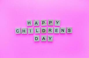 novembre 20, universale bambini giorno, minimalista bandiera con il iscrizione nel di legno lettere su un' rosa sfondo foto