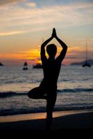 sagoma del modello di fitness che fa yoga all'ora del tramonto sunset foto