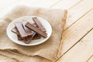 barrette di cioccolato su fondo in legno foto