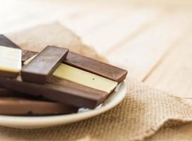 barrette di cioccolato su fondo in legno foto