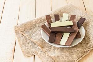 barrette di cioccolato su fondo in legno foto