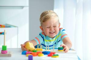 poco ragazzo 2 anni vecchio è giocato con un' colori giocattoli. educativo logica giocattoli per bambini. Montessori Giochi per bambino sviluppo. foto