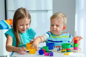 sorella aiuta poco fratello per montare il piramide. educativo logico giocattoli per bambini. Montessori Giochi per bambino sviluppo. foto
