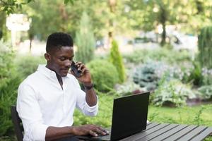 uomo d'affari afroamericano, lavora al computer portatile in un bar, libero professionista foto