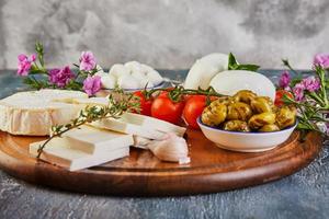 formaggi di diverse forme e gusti con pomodorini foto