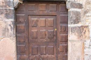 antica porta in legno con facciata in pietra foto