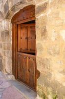 antica porta doppia in legno con facciata in pietra foto