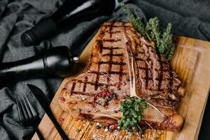 un' grande grigliato bistecca su un' di legno piatto foto