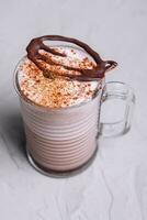 bicchiere di caffè latte macchiato con cioccolato polvere foto