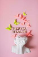 un' figurina di un' testa con farfalle su un' colorato sfondo. mentale Salute testo creativo concetto foto