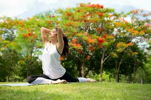 giovane femmina con all'aperto attività nel il città parco, yoga è sua scelto attività. foto
