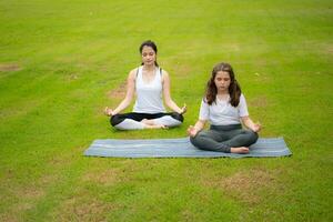 giovane femmina e poco ragazza con all'aperto attività nel il città parco, yoga è sua scelto attività. foto