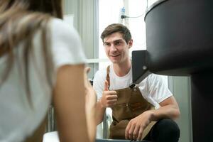 giovane uomo e donna Lavorando nel caffè fagioli torrefattore, essi siamo controllo di caffè fagioli arrostito. foto