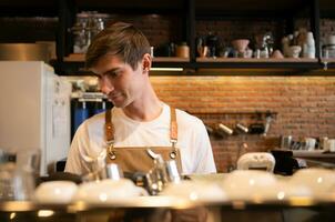 ritratto di un' giovane maschio barista preparazione caffè nel un' caffè negozio foto