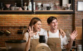 ritratto di un' giovane maschio e femmina barista nel un' caffè negozio foto