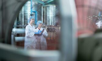 Due giovane femmina scienziati Lavorando con tavoletta computer nel potabile acqua pianta foto