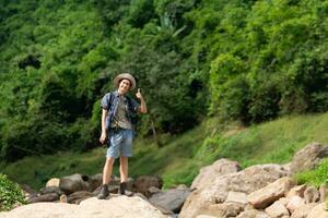 giovane uomo con zaino escursioni a piedi nel il foresta. attivo stile di vita concetto. foto